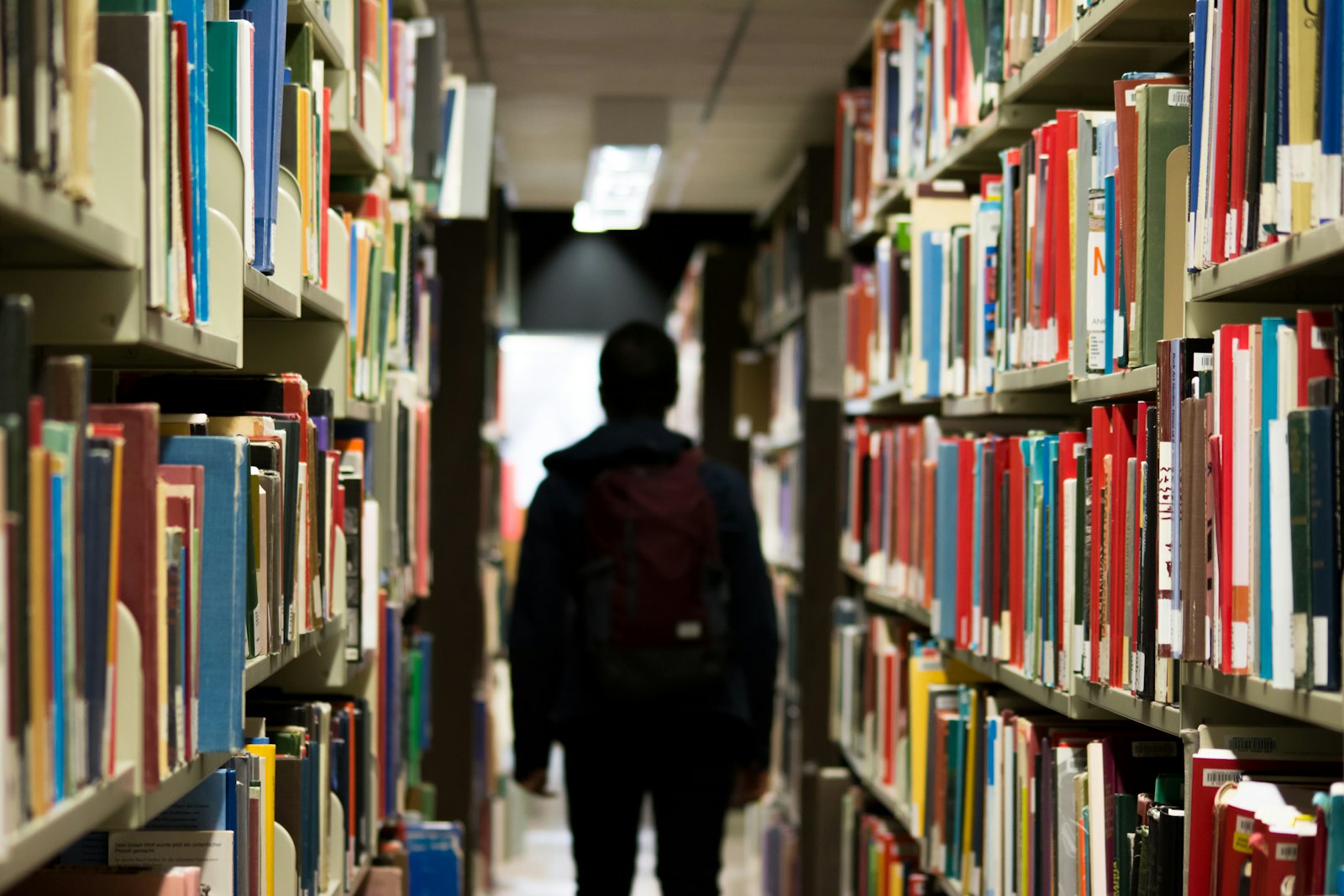 学生在学校图书馆内走动,背负书包